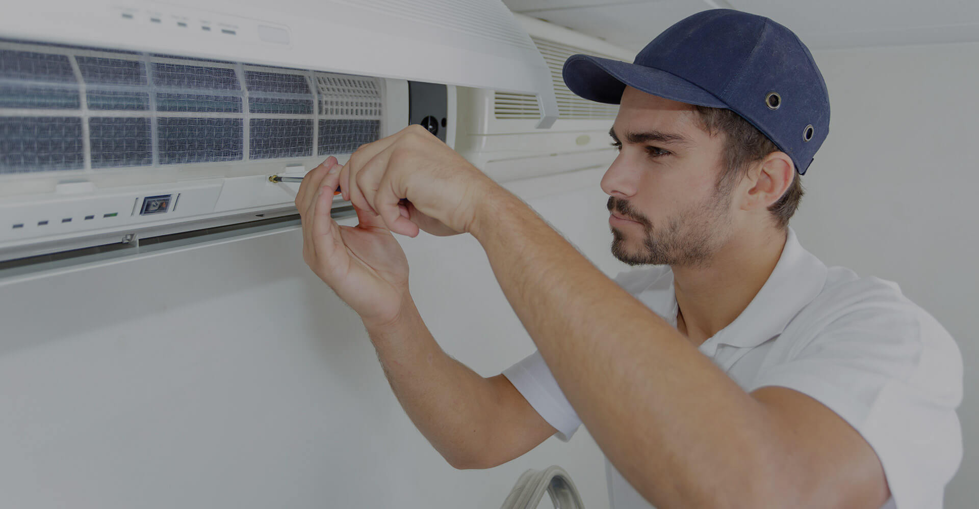 HVAC technician servicing a wall-mounted air conditioning unit